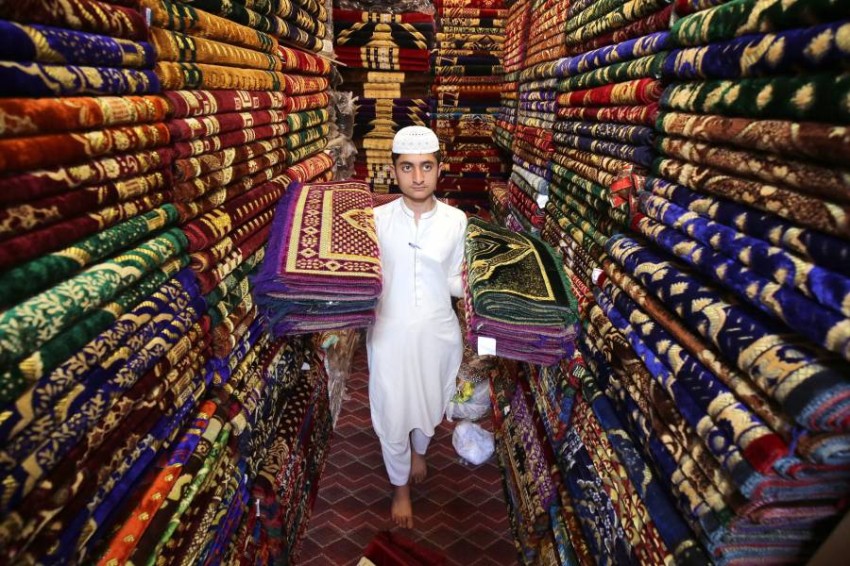 بائع يعرض أنواعًا مختلفة من سجاد الصلاة في أحد الأسواق في بيشاور ، باكستان.  خلال شهر رمضان المبارك ، يزداد شراء المسابح وسجاد الصلاة وغطاء الصلاة.