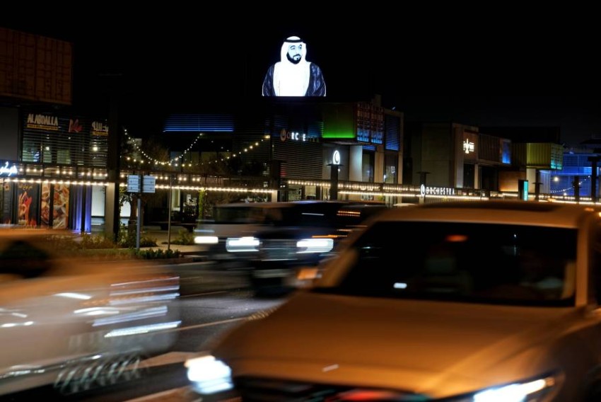 سيارات تمر أمام صورة للشيخ خليفة بن زايد آل نهيان على لوحة إعلانات في دبي تعلن خبر وفاة الشيخ خليفة بن زايد